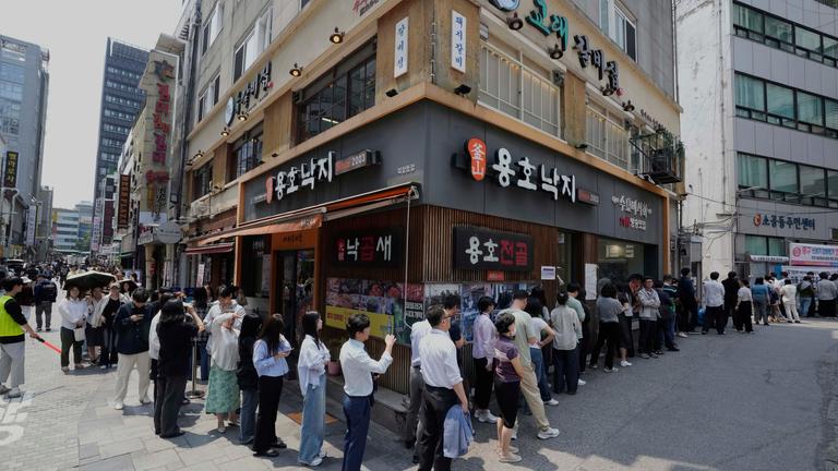 Südkorea, Seoul: Menschen stehen in der Nähe eines Wahllokals in Seoul, Südkorea, Schlange. 