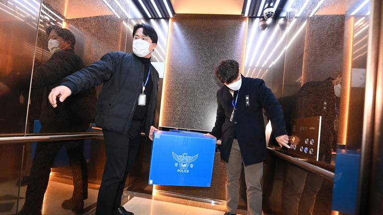 Ermittler der Polizei tragen Gegenstände aus dem Muan-Büro des Busan Regional Office of Aviation in einen Aufzug am Muan International Airport, Südkorea