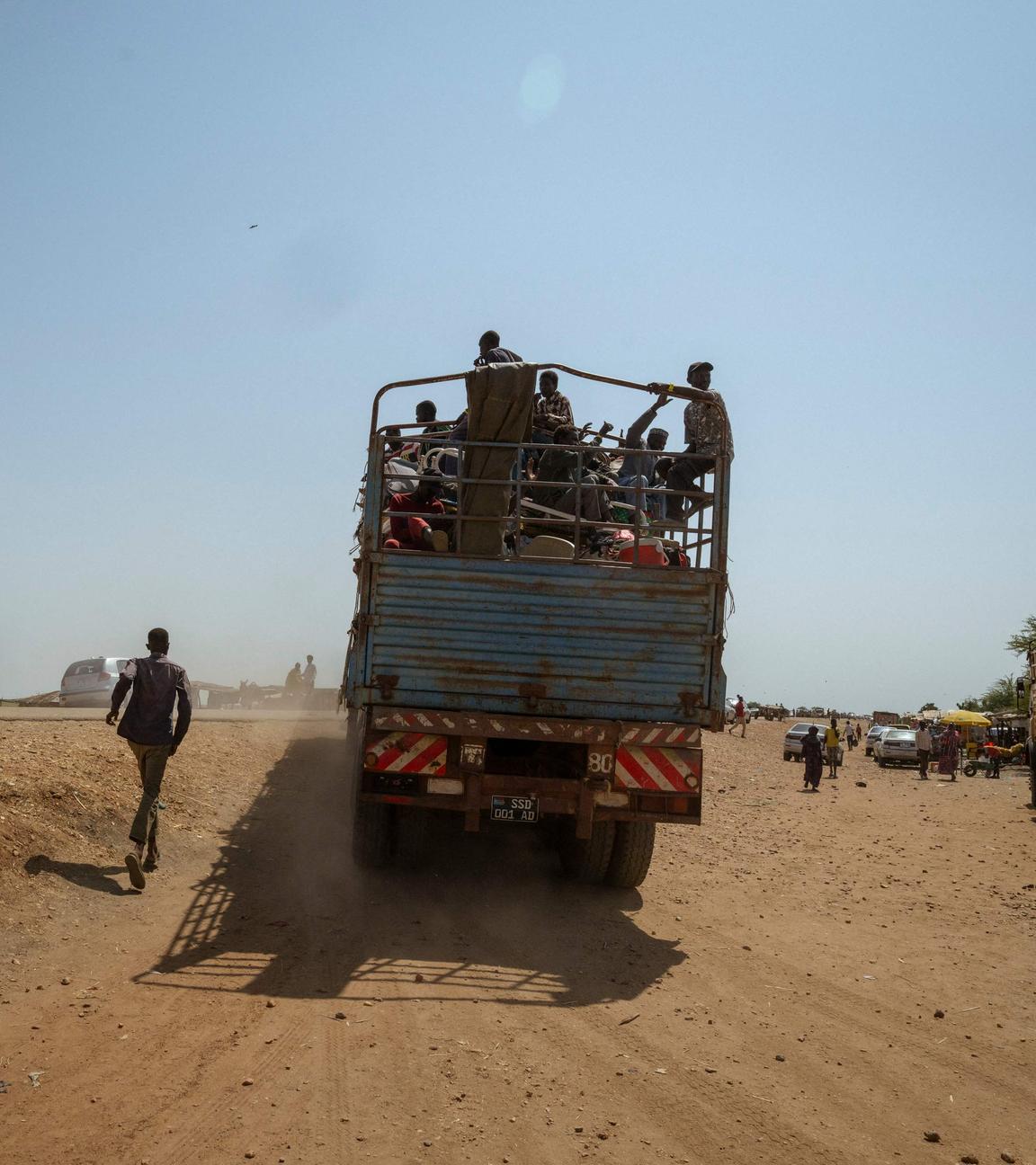 Ein Mann rennt einem voll beladenen Lastwagen hinterher, der den Grenzübergang Joda-Wunthow im Bezirk Renk im Bundesstaat Upper Nile im Südsudan verlässt.