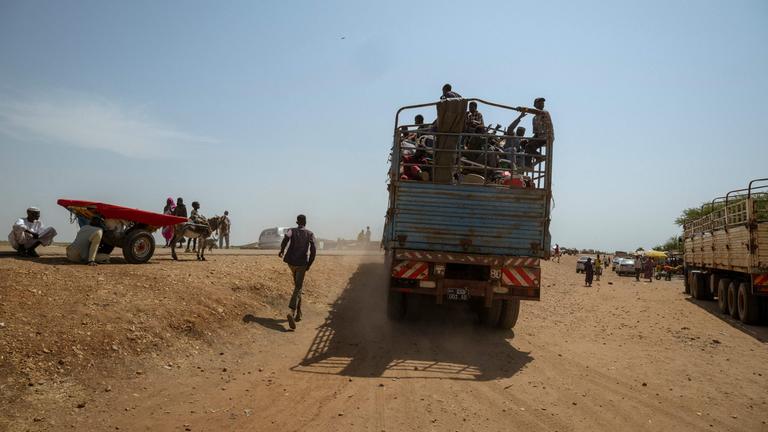 Ein Mann rennt einem voll beladenen Lastwagen hinterher, der den Grenzübergang Joda-Wunthow im Bezirk Renk im Bundesstaat Upper Nile im Südsudan verlässt.