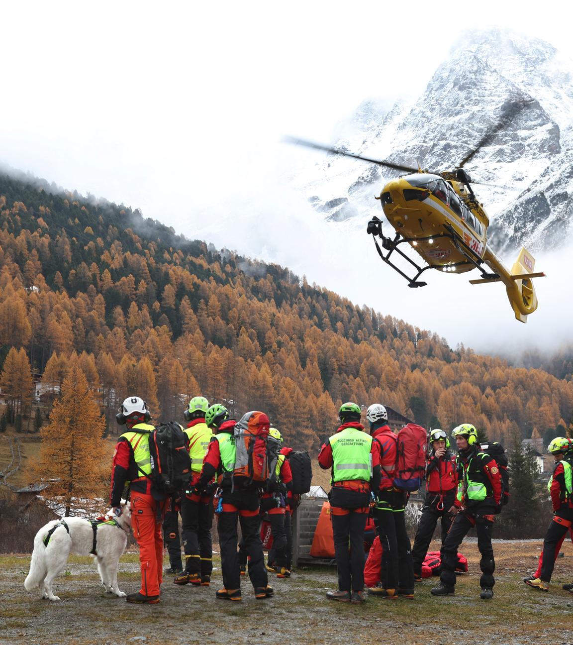 Ein Hubschrauber der Bergrettung landet vor Bergrettern in Bozen, Italien.