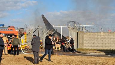 Feuerwehrleute und Mitglieder des Rettungsteams arbeiten auf dem internationalen Flughafen von Muan.