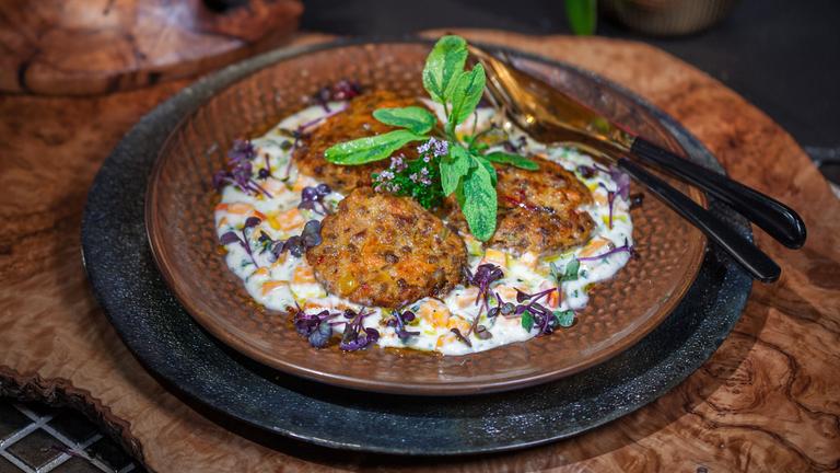 Süßkartoffel-Pflanzerl mit Käsesoße schick angereichtet auf einem Teller