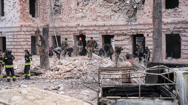 Rettungskräfte räumen die Trümmer eines Gebäudes weg, das von einem russischen Raketenangriff auf Sumy in der Ukraine getroffen wurde.