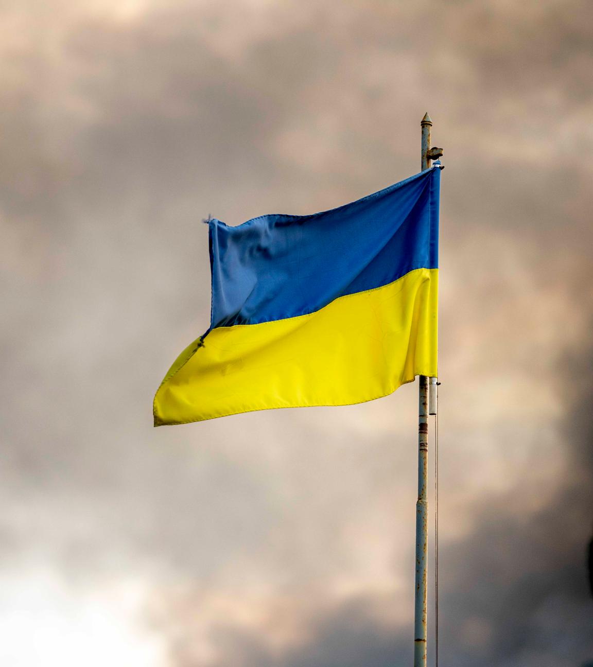 Ukrainische Flagge weht vor Rauch