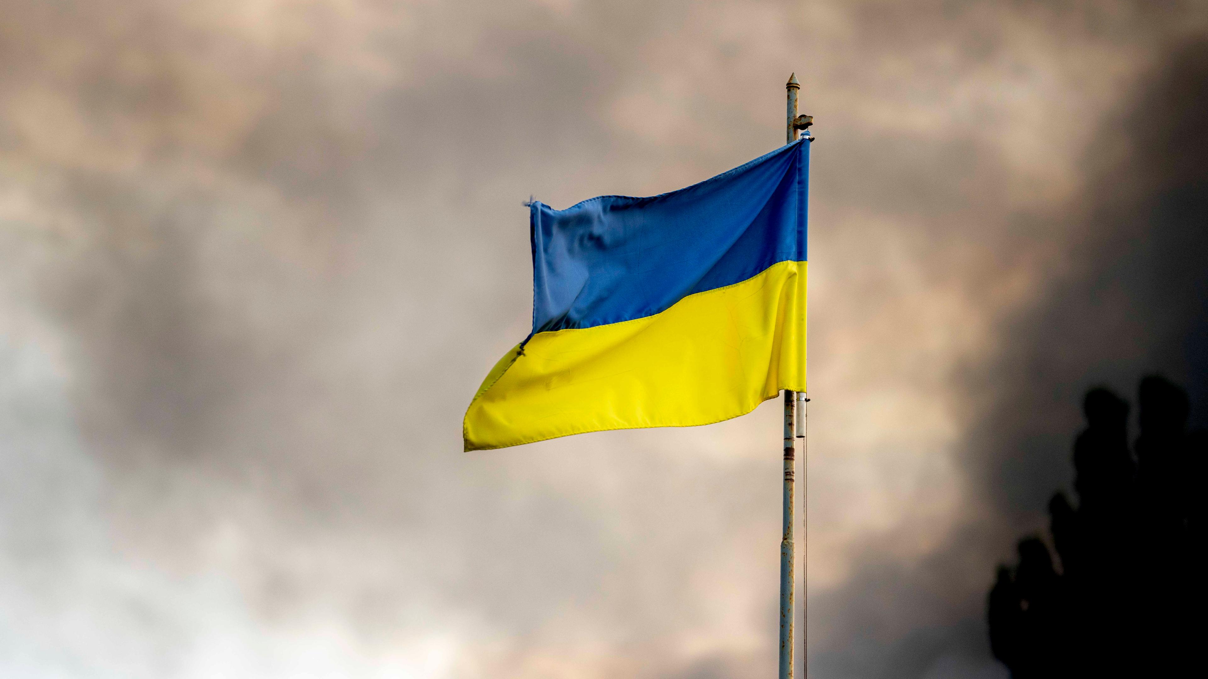 Ukrainische Flagge weht vor Rauch