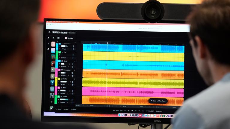 Während der Erstellung eines KI-Musikstücks bei SUNO werden Wellenformen von Audiodateien verschiedener Instrumente auf einem Computerbildschirm angezeigt