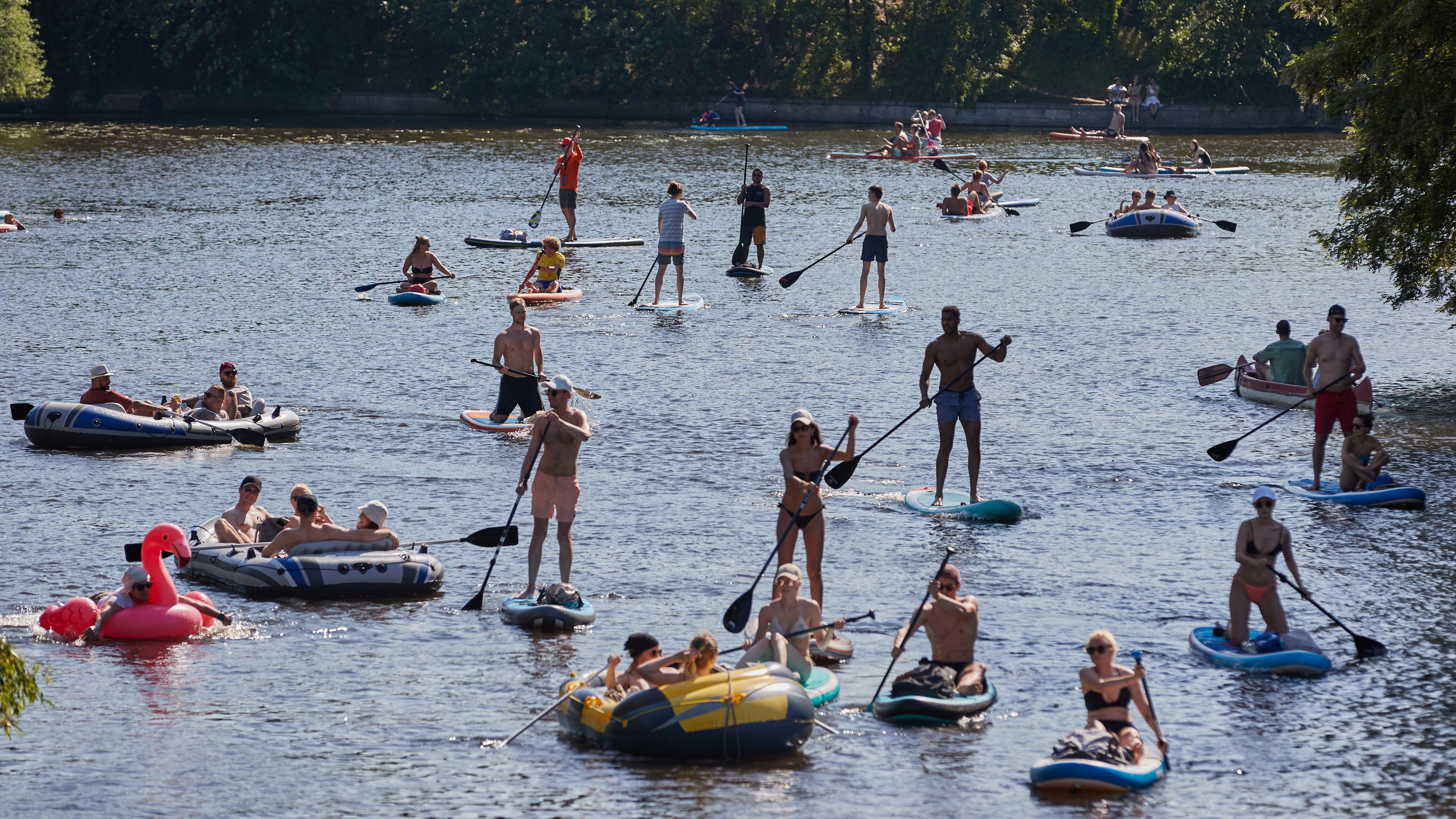 Stand-up-Paddler genießen am Sonntag bei sommerlich warmen Temperaturen ihren Ausflug auf einem Kanal der Außenalster in Hamburg-Winterhude