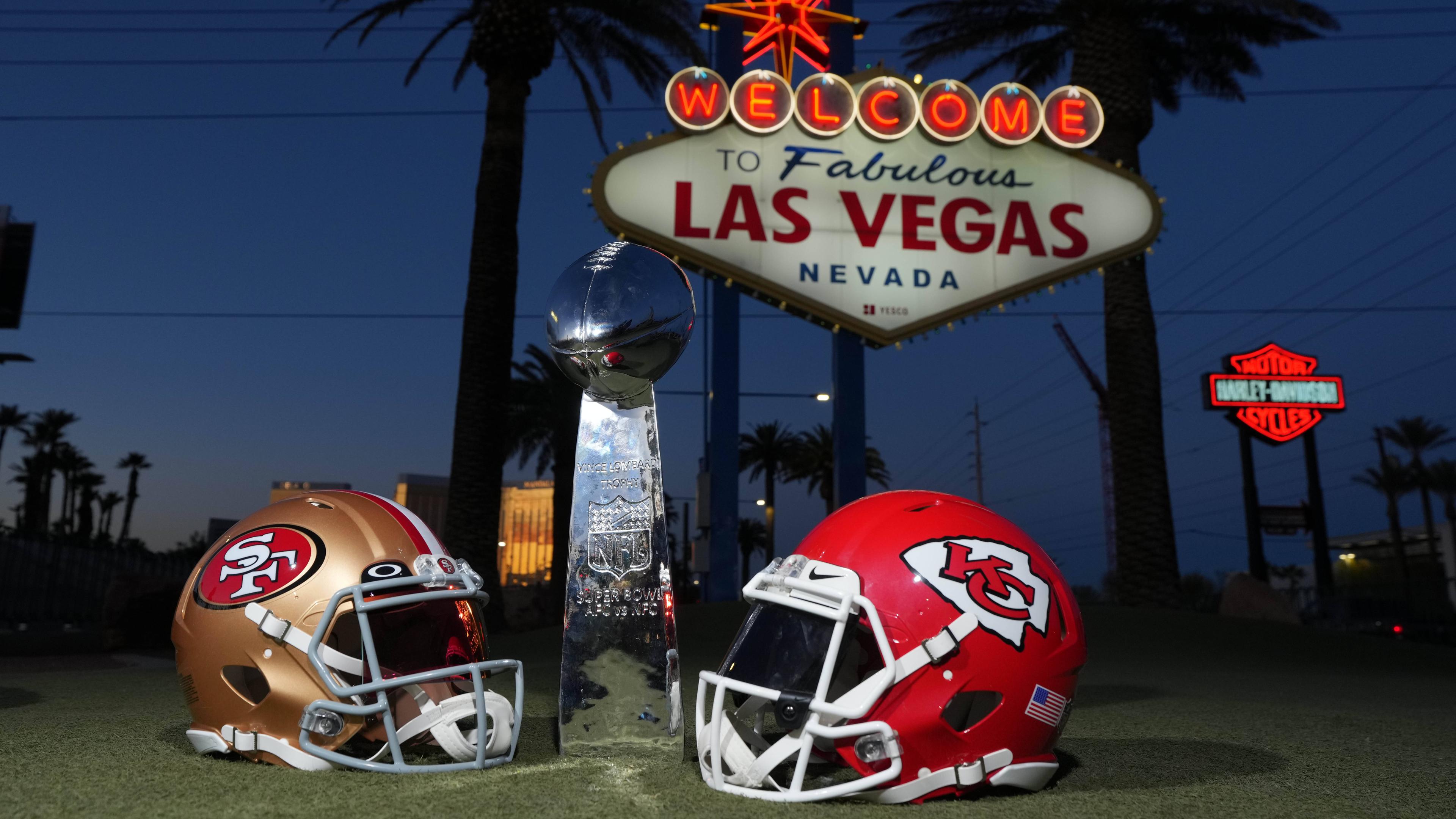 Helme der San Francisco 49ers und der Kansas Chiefs sowie die Vince Lombardi Trophy am Schild Welcome to Fabulous Las Vegas.