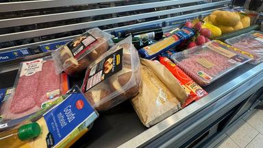 Lebensmittel liegen auf einem Kassenband an einer Supermarktkasse.