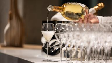Ein Kellner schenkt ein Glas Champagner ein