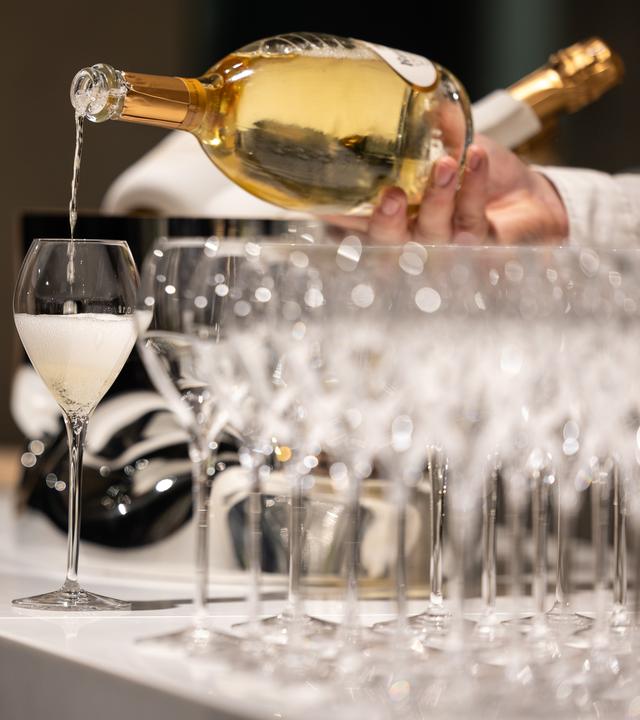Ein Kellner schenkt ein Glas Champagner ein