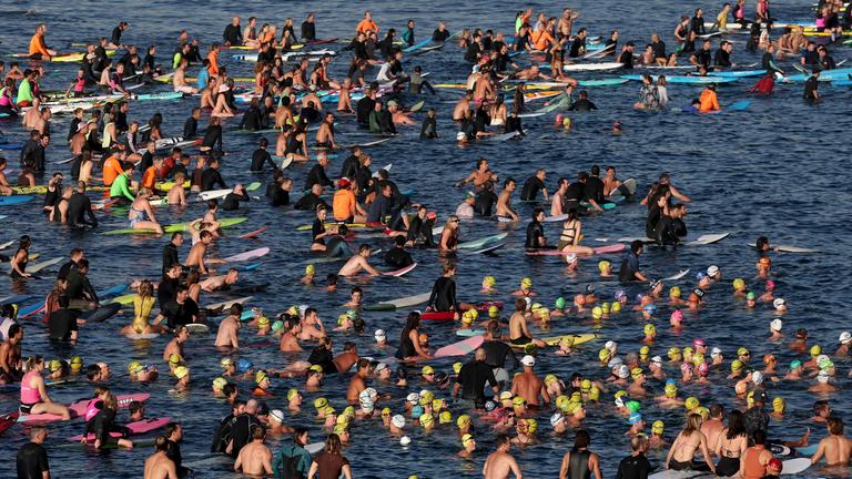 Surfer gedenken der Opfer des Terroranschlags am Bondi Beach in Sydney. 