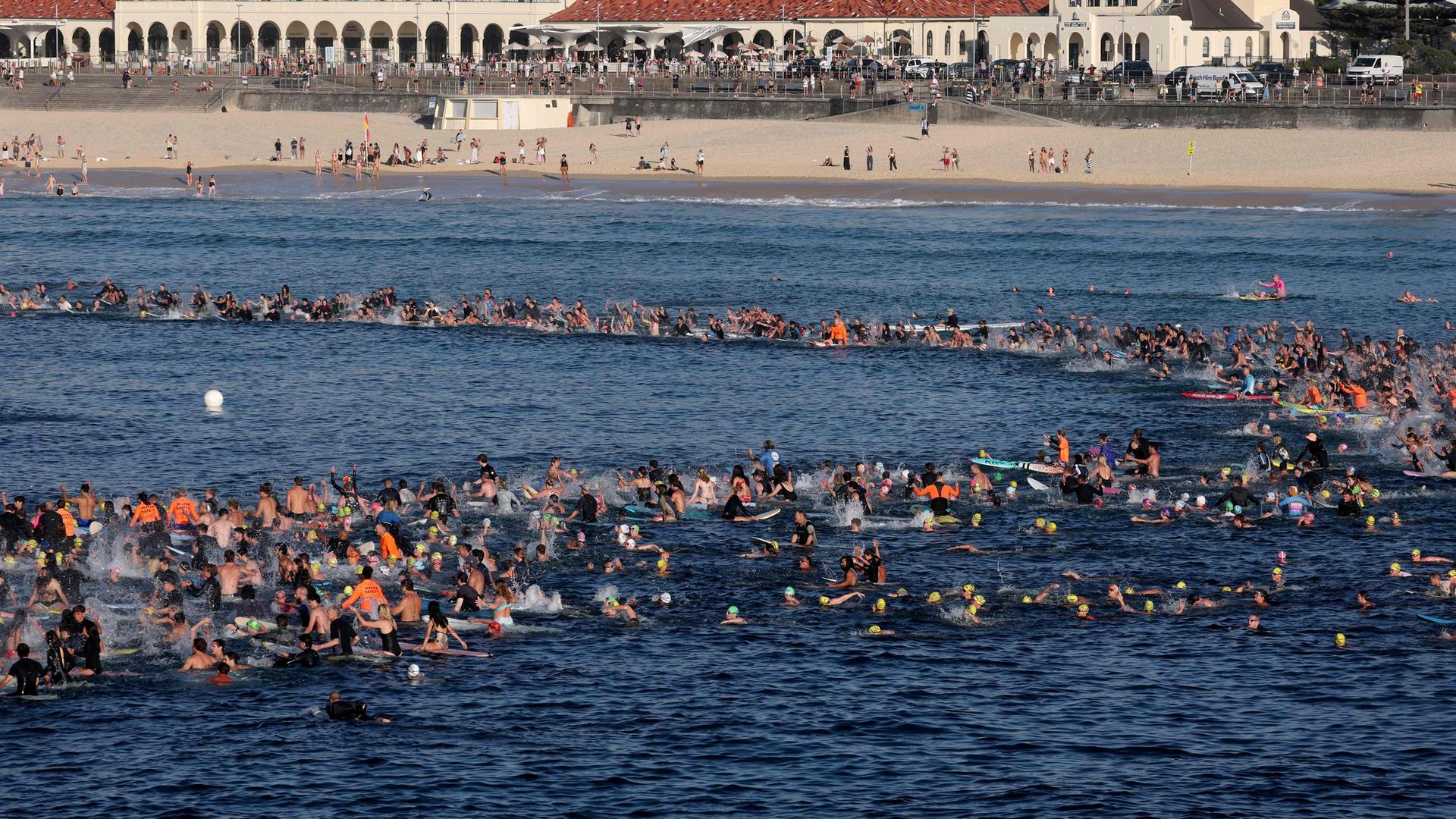 Sufer gedenken der Opfer der Terroranschlags am Bondi Beach in Sydney.