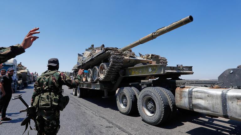 Ein Panzer der syrischen Regierungstruppen, der auf einem Lastwagen transportiert wird, fährt während des Rückzugs aus Suweida in Richtung Süd-Syrien.