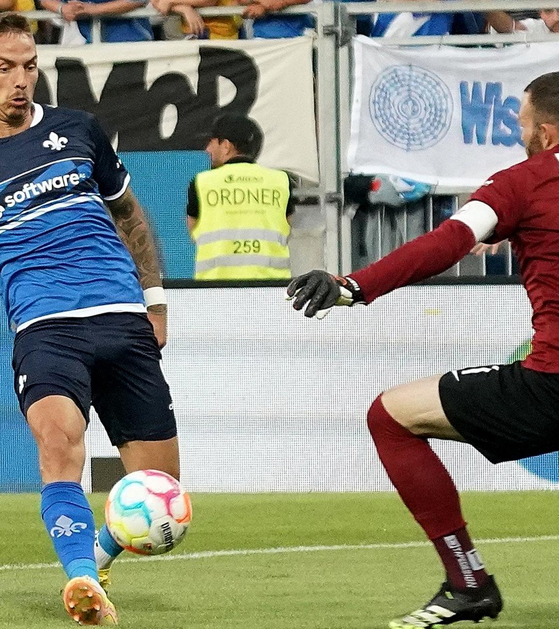 Phillip Tietz (l) von Darmstadt erzielt das Tor zum 1:0 gegen Rostocks Torwart Markus Kolke am 13.08.2022.