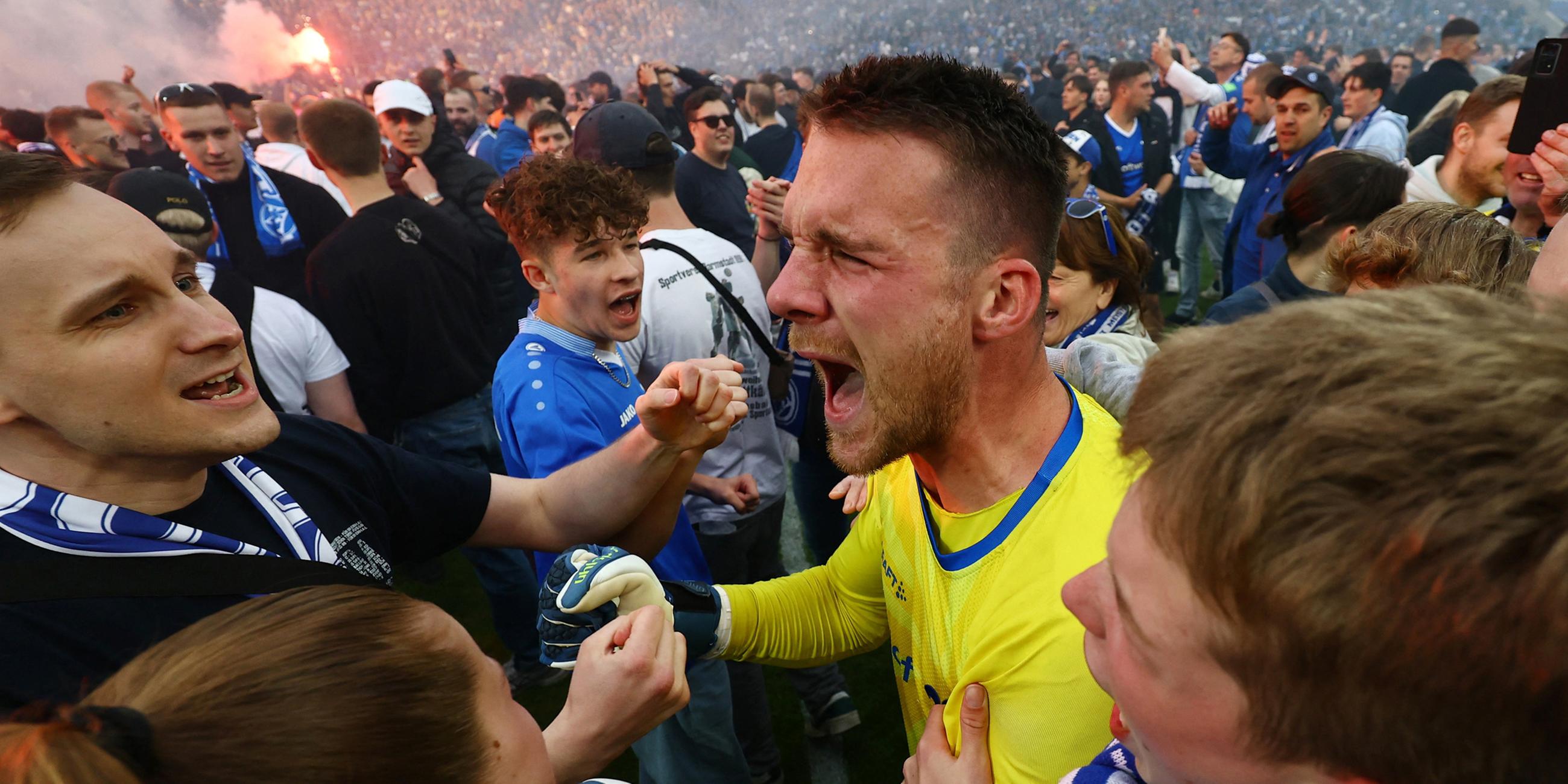 Marcel Schuhen (SV Darmstadt) freut sich mit den Fans über den Aufstieg.