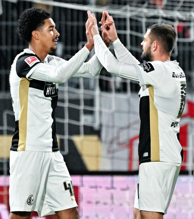 Torschütze Francis Onyeka (l, SV 07 Elversberg) jubelt mit Mannschaftskollegen über das Tor zum 2:0.