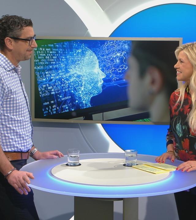 ZDF-Redakteur Sven-Hendrik Hahn und Moderatorin Nadine Krüger stehen an einem Tisch. 