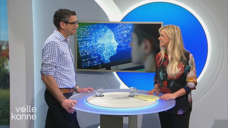 ZDF-Redakteur Sven-Hendrik Hahn und Moderatorin Nadine Krüger stehen an einem Tisch. 