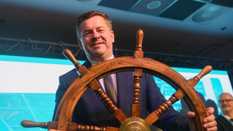 Sven Schulze (CDU), Minister für Wirtschaft, Tourismus, Landwirtschaft und Forsten des Landes Sachsen-Anhalt, steht mit einem Steuerrad auf der Bühne der Landesvertreterversammlung der CDU. Die Delegierten wollen die Listenaufstellung der CDU Sachsen-Anhalt für die Landtagswahl 2026 beschließen. Sven Schulze war zum Spitzenkandidaten der CDU für die kommende Landtagswahl gewählt worden.