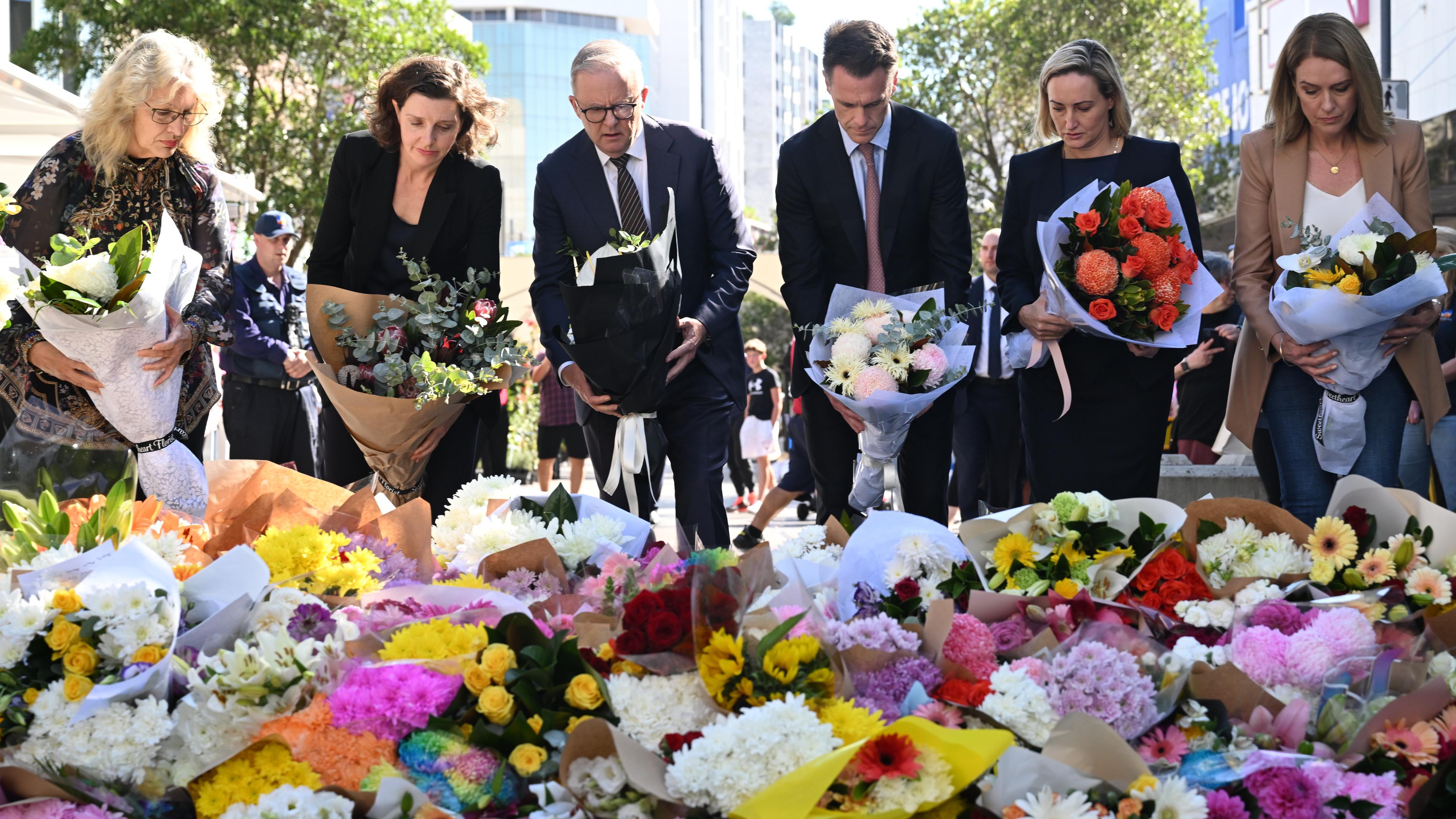 Australiens Premierminister Anthony Albanese (m) legt gemeinsam mit anderen Politikern Blumen am Tatort eines Messerangriffs in Sydney nieder.