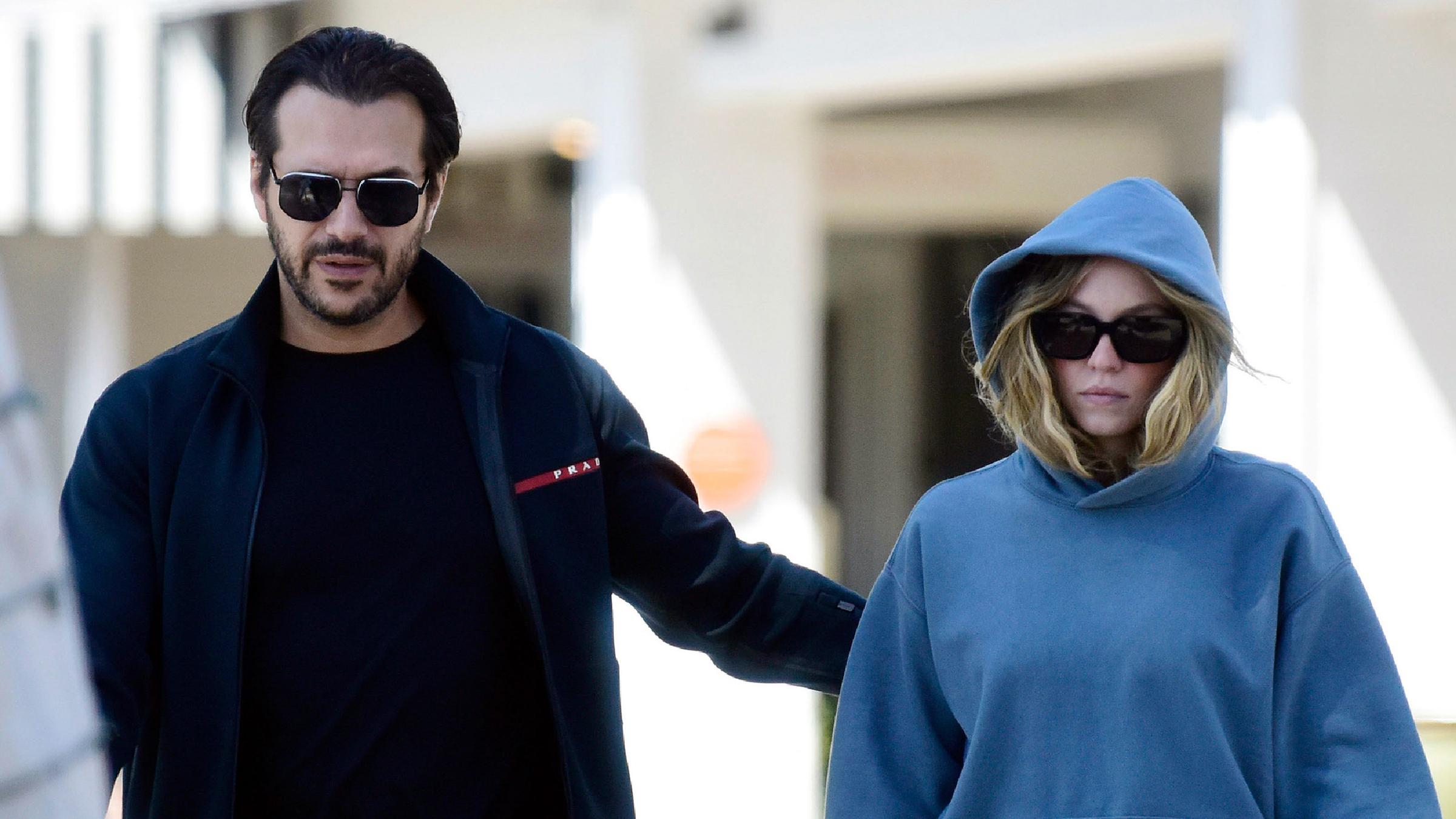 Sydney Sweeney in blauem Kapuzenpullover und Sonnenbrille mit ihrem Verlobten Jonathan Davino bei einem Spaziergang.