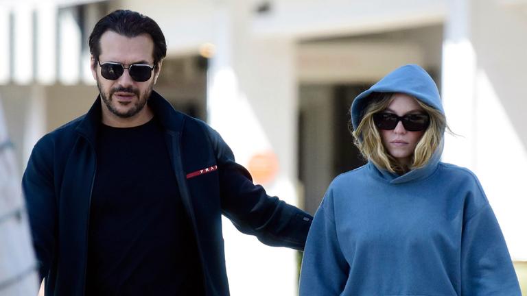 Sydney Sweeney in blauem Kapuzenpullover und Sonnenbrille mit ihrem Verlobten Jonathan Davino bei einem Spaziergang.