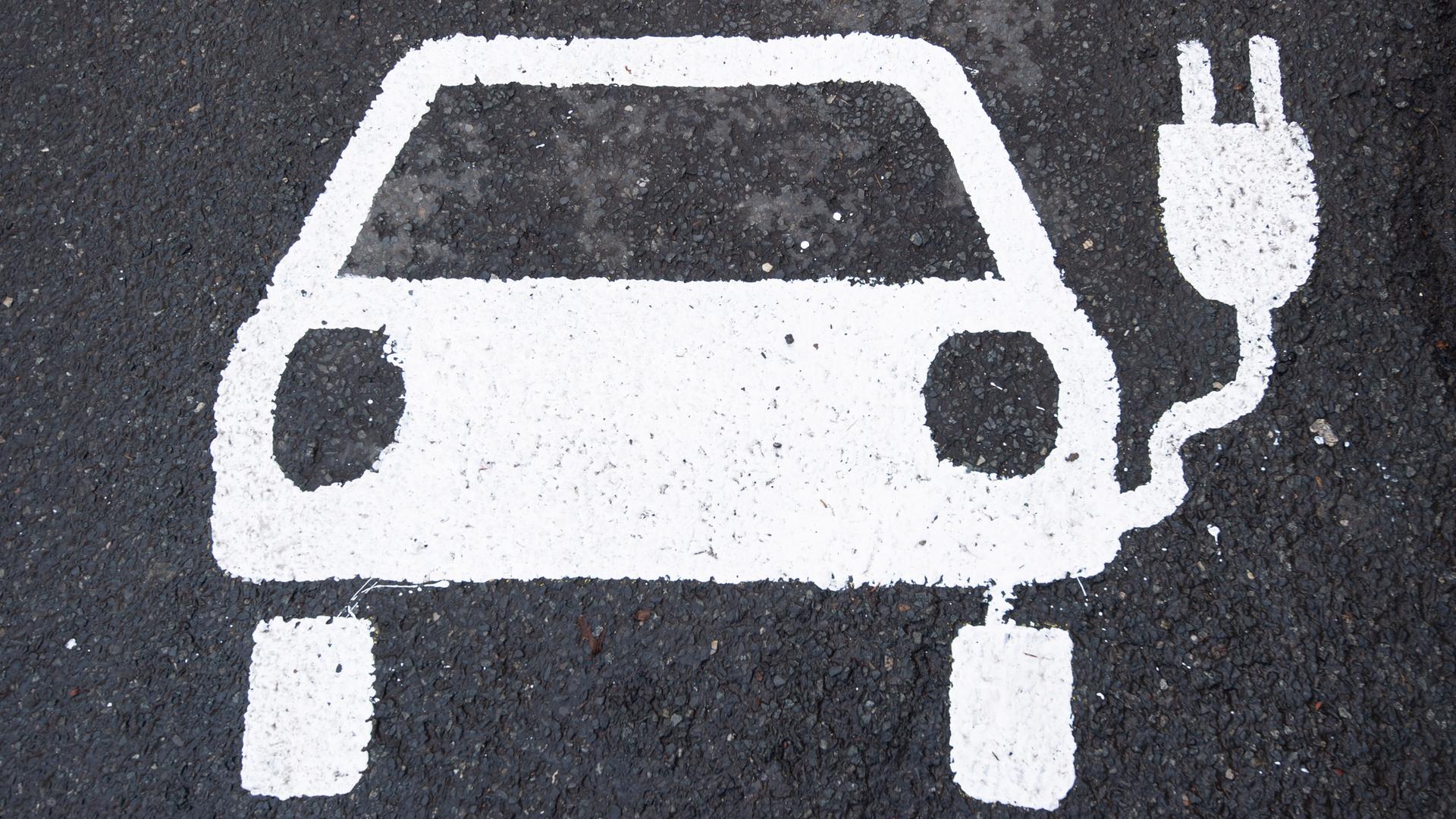 Symbol eines E-Autos auf einer Straße.