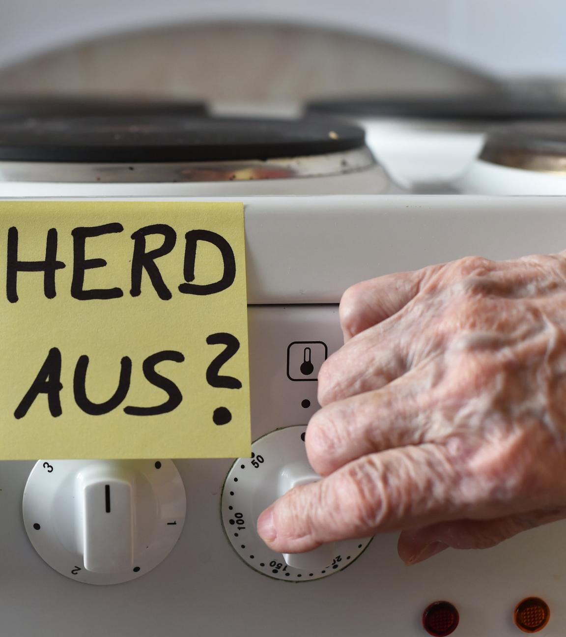 Ein Klebezettel mit dem Schriftzug «Herd aus?» klebt an einem Herd neben den Drehknöpfen.