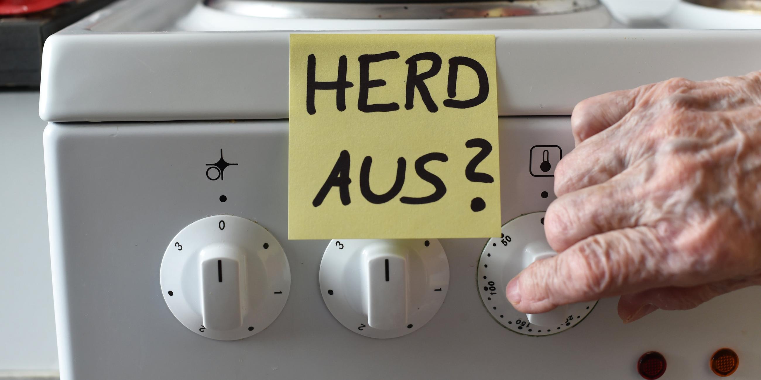Ein Klebezettel mit dem Schriftzug «Herd aus?» klebt an einem Herd neben den Drehknöpfen.