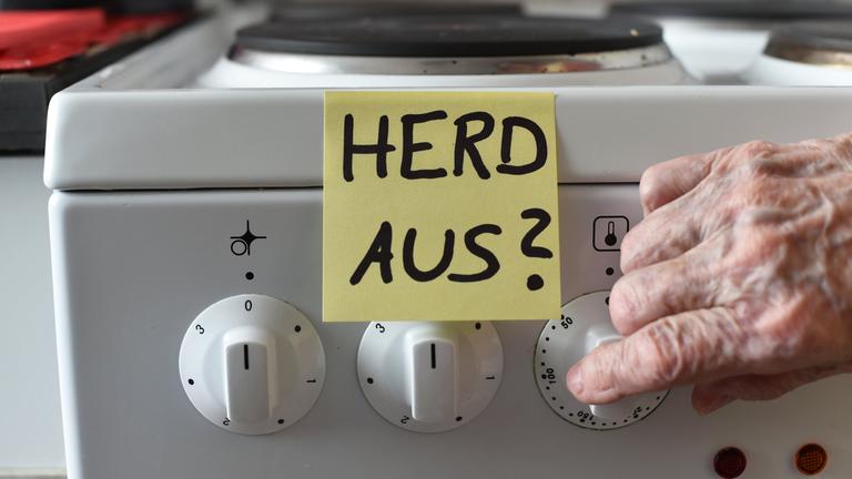 Ein Klebezettel mit dem Schriftzug «Herd aus?» klebt an einem Herd neben den Drehknöpfen.