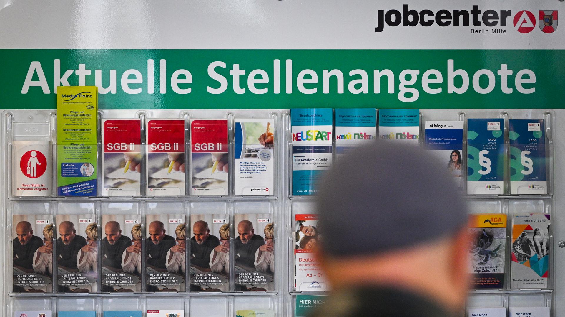 Flyer werden auf einer Tafel mit der Überschrift Aktuelle Stellenangebote im Jobcenter Berlin Mitte am Tag der Möglichkeiten angeboten