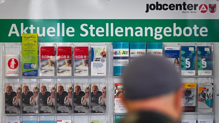 Flyer werden auf einer Tafel mit der Überschrift Aktuelle Stellenangebote im Jobcenter Berlin Mitte am Tag der Möglichkeiten angeboten