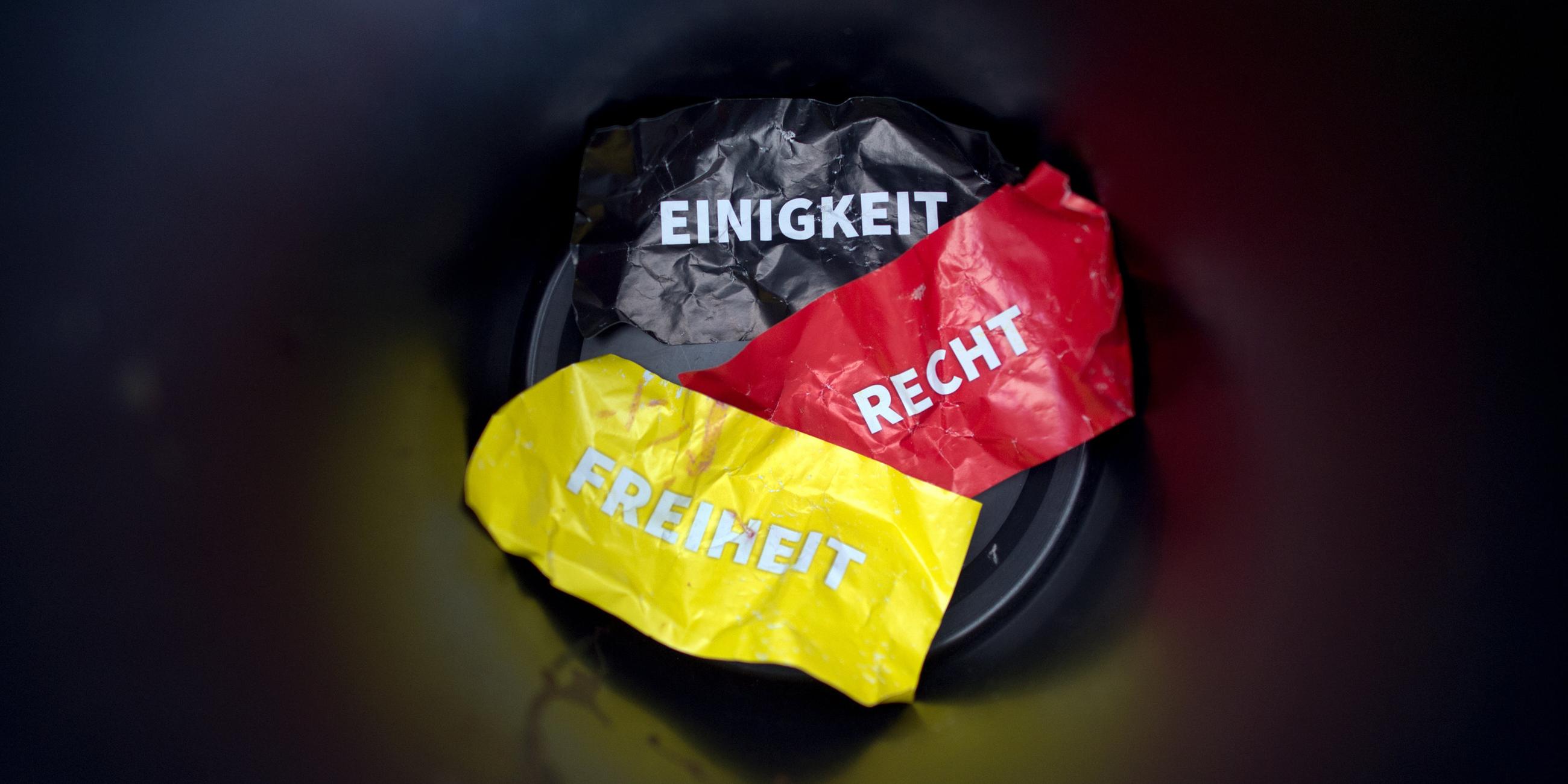 die worte «einigikeit, recht und freiheit» auf flyern in den deutschen nationalfarben