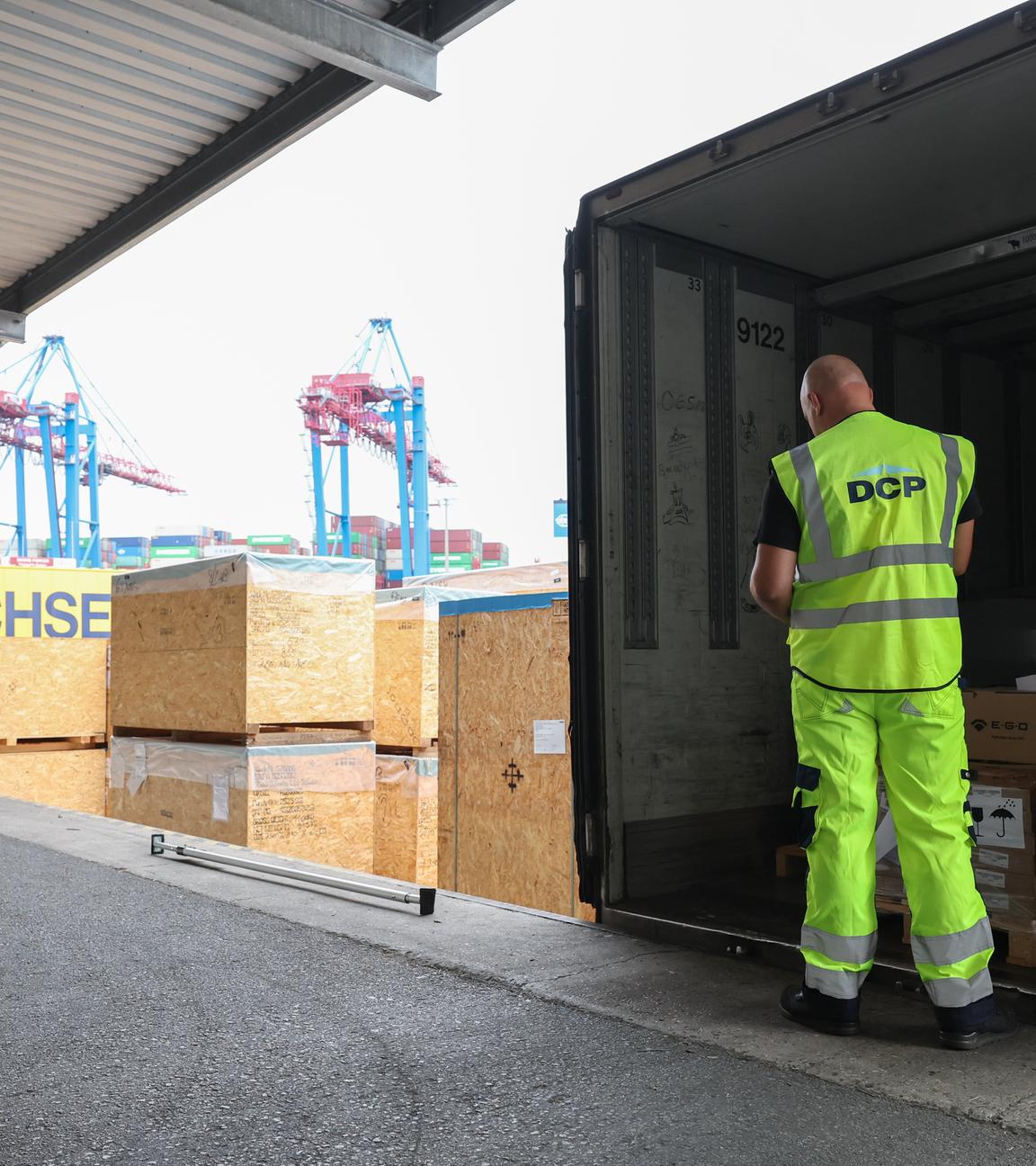 Arbeiter überprüft Beladung eines LKW-Anhängers am Hamburger Hafen