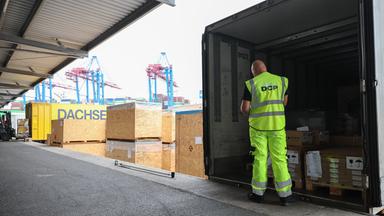 Arbeiter überprüft Beladung eines LKW-Anhängers am Hamburger Hafen