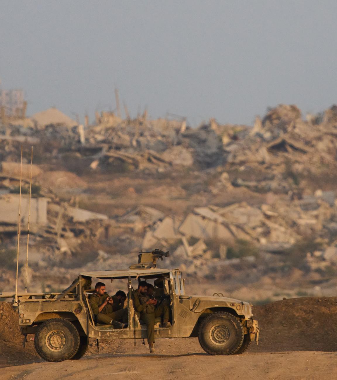 Ein Auto steht vor einer durch Krieg zerstörten Landschaft