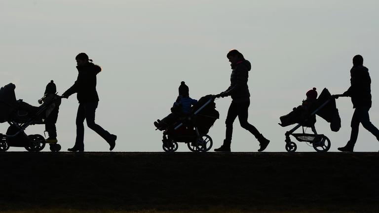 Drei Mütter schieben auf dem Berg «Höchsten» ihre Kinderwagen eine Landstraße entlang.