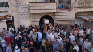 Mourners carry the coffin of Mohammad Ghamira, a former White Helmets volunteer who died shortly after his release from jail, for burial in the village of al-Haffa, in Latakia province, Syria, Monday, Aug. 17, 2026.