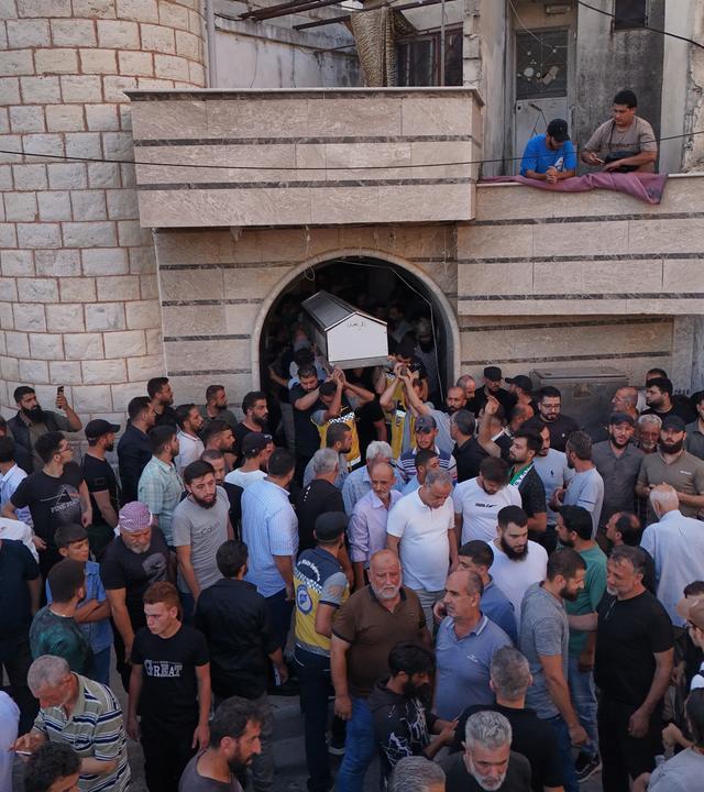 Mourners carry the coffin of Mohammad Ghamira, a former White Helmets volunteer who died shortly after his release from jail, for burial in the village of al-Haffa, in Latakia province, Syria, Monday, Aug. 17, 2026.