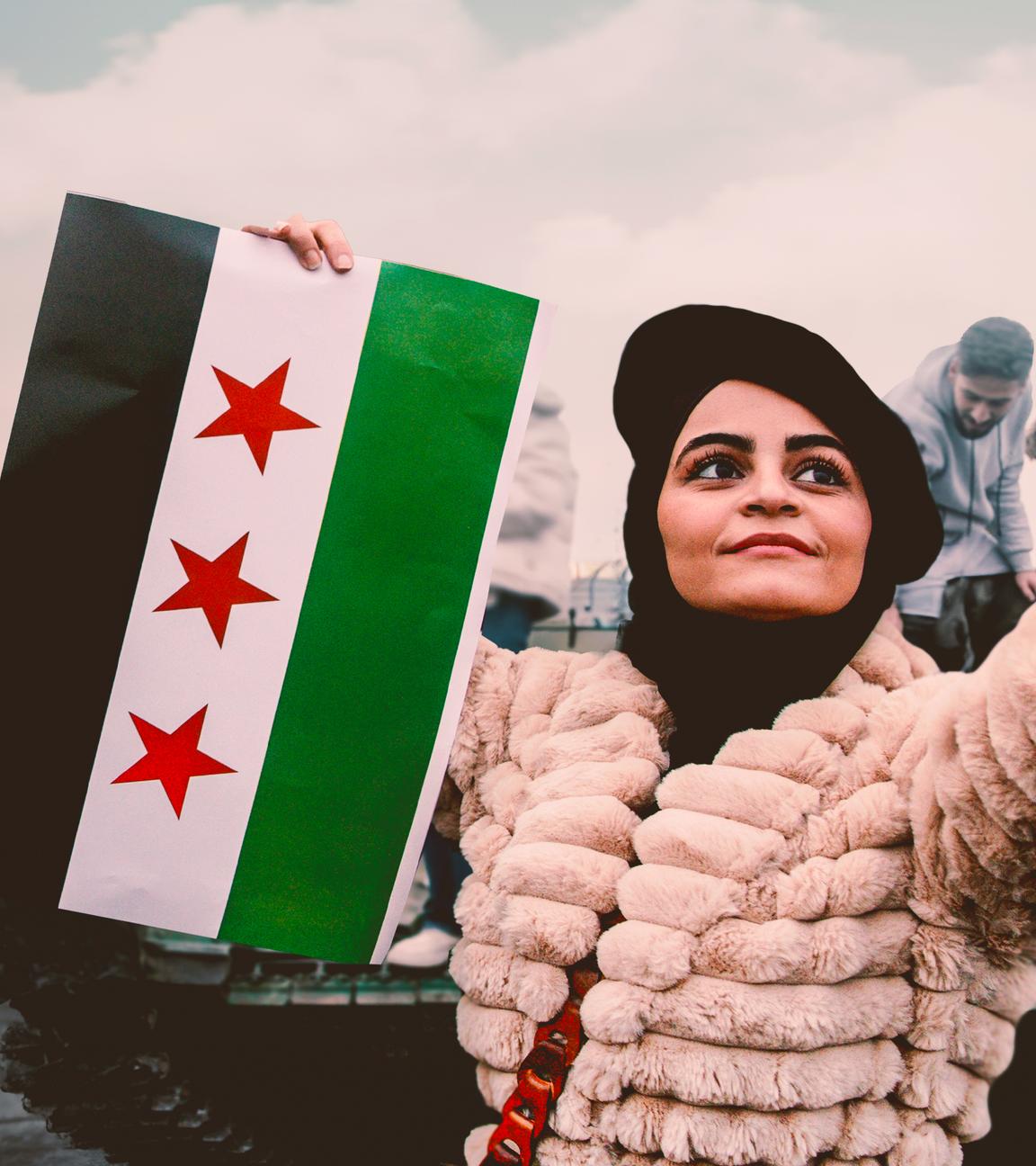 Eine Frau macht ein Selfie. Sie hält in einer Hand ein Smartphone, in der anderen Hand eine syrische Fahne. Im Hintergrund befinden sich Männer auf einem Panzer.