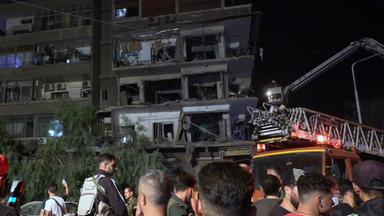 Syrische Soldaten und Menschen begutachten die Schäden nach dem Einschlag von Raketen auf das Gebäude im Viertel Al-Mazzeh in Damaskus