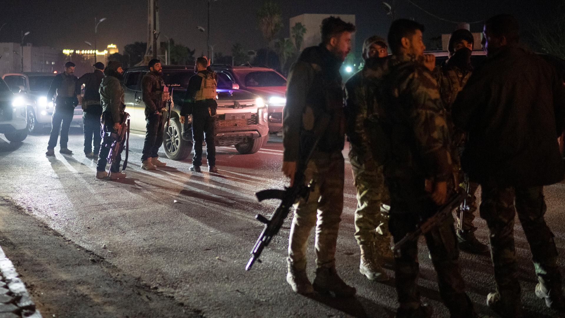  Syrische Kämpfer versammeln sich in der Nacht auf einer Straße in Damaskus.