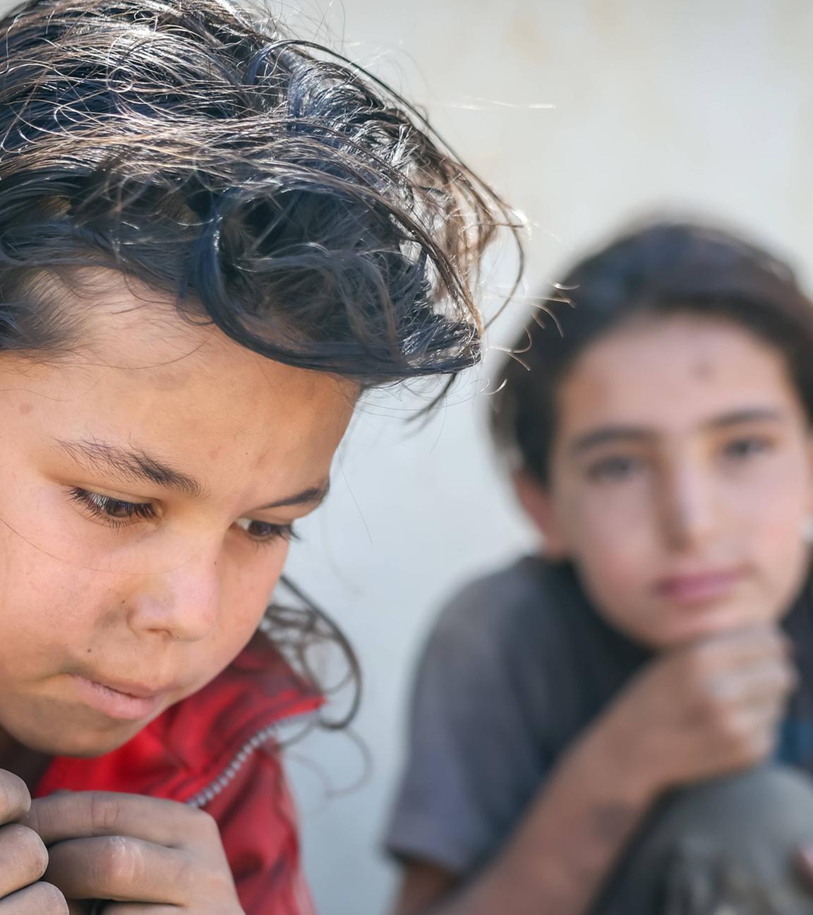 Zwei syrische Mädchen in zerlumpten Kleidern sitzen am Straßenrand, nachdem sie am 02.09.2025 Müll nach Plastikresten durchsucht haben, die sie verkaufen können, um ihre Familie in Damaskus zu unterstützen.