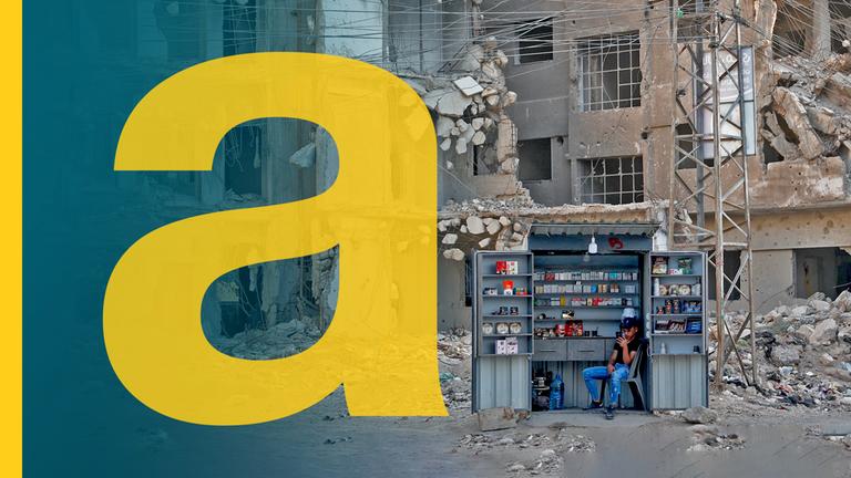 Ein Kiosk vor zerstörten Häusern in Damaskus