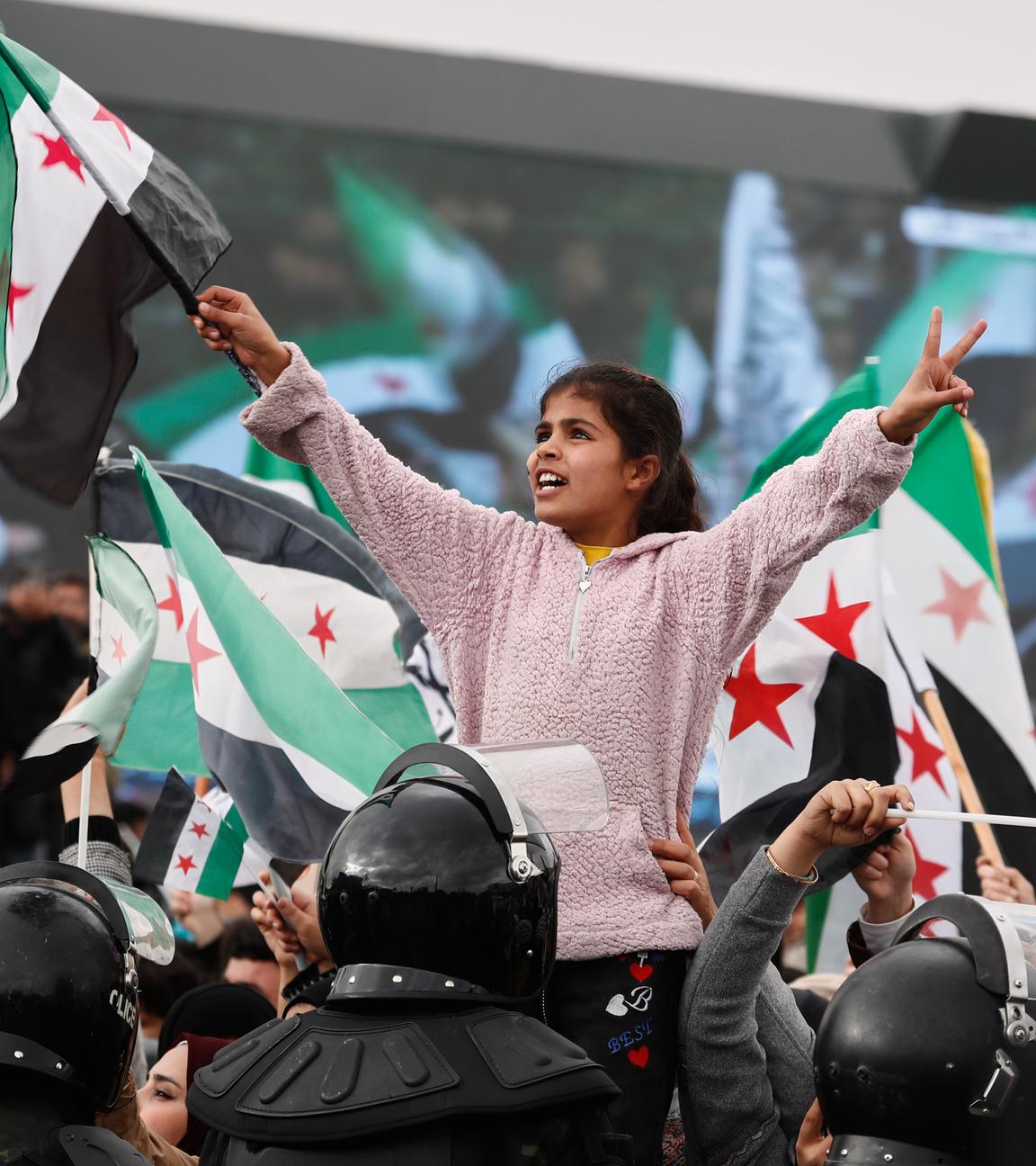 Menschen schwenken syrische Flaggen bei einer Feier zum ersten Jahrestag des Sturzes des ehemaligen Präsidenten Baschar al-Assad in Damaskus, Syrien, am Montag, dem 8. Dezember 2025.