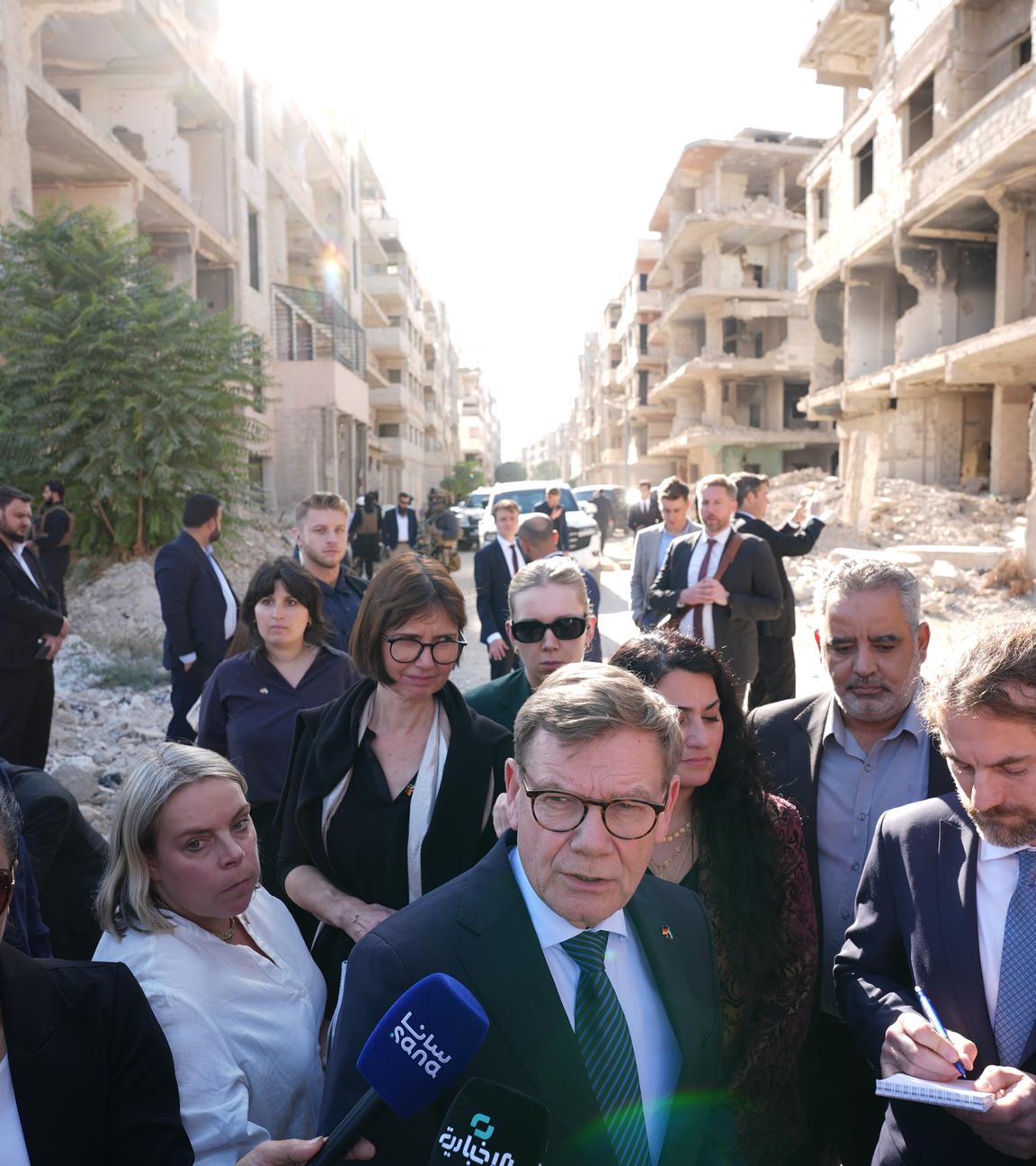 Johann Wadephul (M, CDU), Bundesminister des Auswärtigen, steht während seines Besuchs eines humanitären Projekts mit Raed Saleh (r).