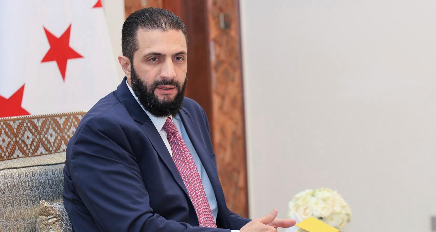 27.07.2025, Syrien, Damaskus: Auf diesem von der amtlichen syrischen Nachrichtenagentur SANA via AP veröffentlichten Foto erhält der syrische Interimspräsident Ahmad al-Sharaa die endgültige Fassung des vorläufigen Wahlsystems für die Volksversammlung.