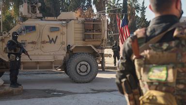 Kämpfer der Syrischen Demokratischen Kräfte (SDF) stehen in der Nähe eines US-Militärfahrzeugs der US-geführten Koalition gegen die Gruppe Islamischer Staat in Deir Hafer. 